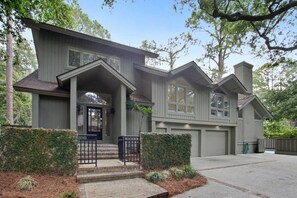 A two-story house with a front porch, a garage, and a well-maintained lawn.
