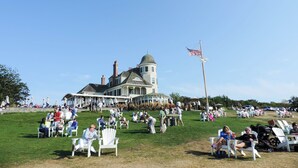 A large, historic house with a distinctive dome and a flagpole with an American flag.