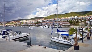 A marina with boats docked, a waterfront promenade, and a hillside town in the background. - New & Stylish Sun Break Apartment in Sveti Vlas (Sveti Vlas)