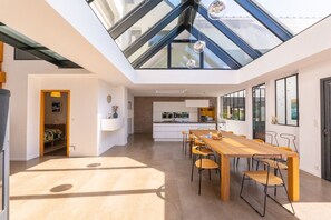 A modern interior with a skylight, a dining area, and a kitchen.