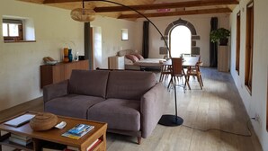 Ein gemütliches Wohnzimmer mit einer Couch, einem Couchtisch und einem Essbereich mit Stühlen und einem Tisch.