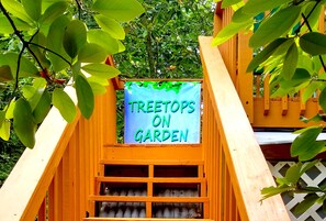 Une structure en bois sur laquelle est apposée une enseigne indiquant : « TREETOPS ON GARDEN ».