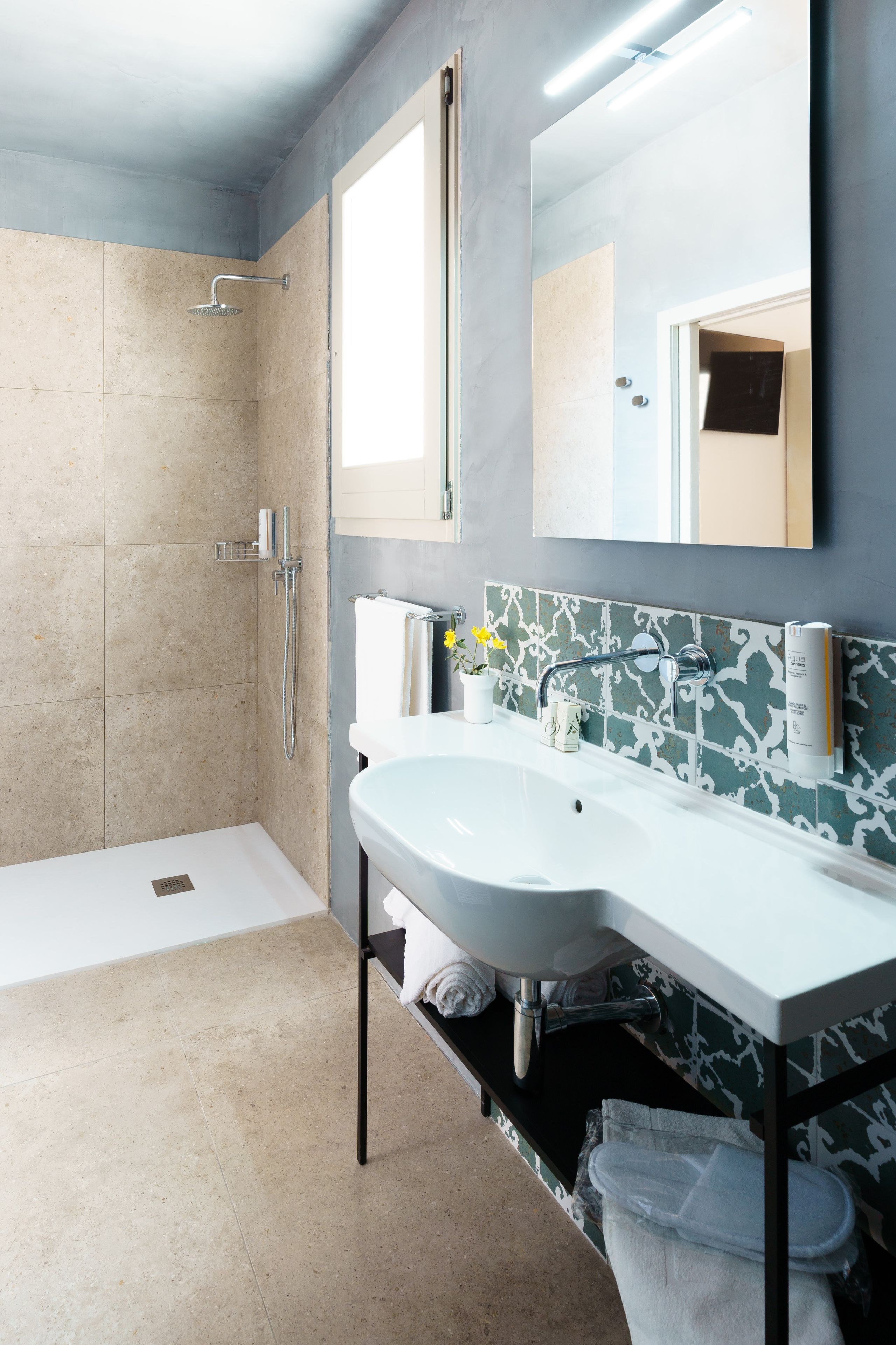 A modern bathroom with a shower, a sink, and a mirror.