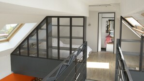 A modern interior with a staircase leading to a loft bedroom.