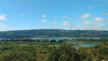 A view of a lake surrounded by dense forest and hills.