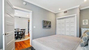 Un dormitorio con cama, armario y zona de comedor.