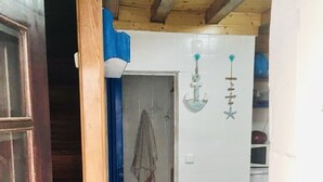 Een compact keuken met een blauw aanrecht, een kruk en een ophangende handdoek.