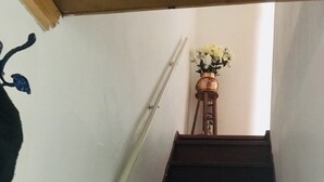 Een trap met een leuning en een kleine tafel met bloemen bovenaan.
