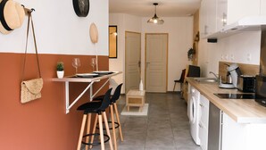 A modern kitchen with a wooden countertop, a washing machine, and a dining area with chairs and a table. - T1 Idéalement Situé Hyper Centre/canal Plus (amiens)