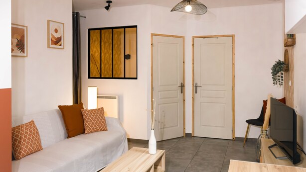 A modern living room with a sofa, coffee table, TV, and two doors. - T1 Idéalement Situé Hyper Centre/canal Plus (amiens)