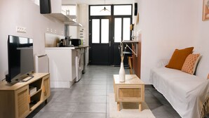 A modern living room with a TV, sofa, and coffee table. - T1 Idéalement Situé Hyper Centre/canal Plus (amiens)