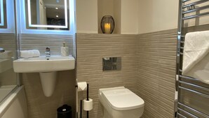 Un bagno moderno con lavandino, WC e portasciugamani.