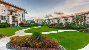 Un resort con un cortile centrale, numerosi balconi e una vegetazione rigogliosa.