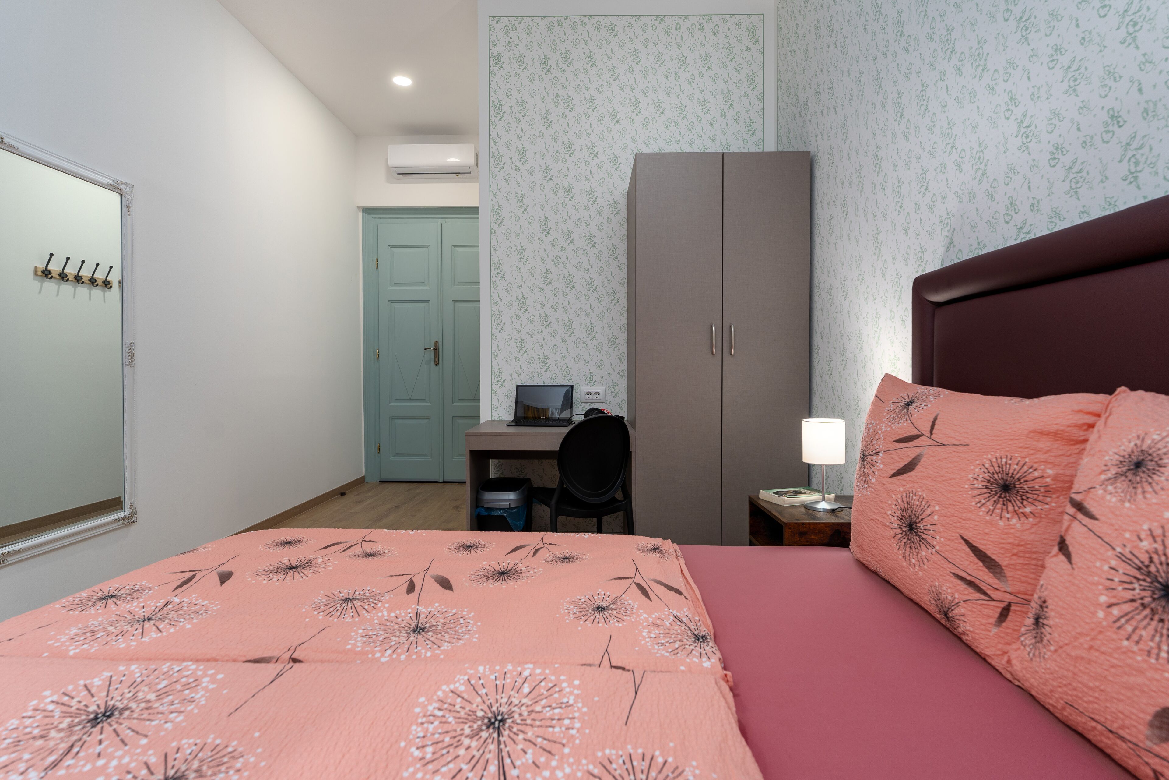 A bedroom with a bed, a desk, a wardrobe, and a chair.