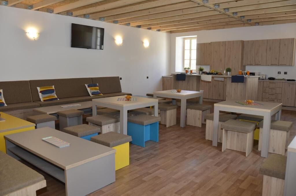 Un espace de vie moderne et ouvert, comprenant une cuisine, un plafond en bois et des sièges intégrés.