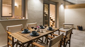 A dining area with a wooden table set for four, surrounded by chairs. - Vertzami Villa just 2km from Lefkada city center (Lefkada)