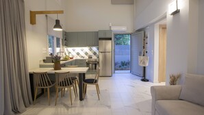 A modern kitchen with grey cabinets, a dining area with a table and chairs, and a sofa in a living area. - Vertzami Villa just 2km from Lefkada city center (Lefkada)