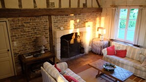 Un salón acogedor con paredes de ladrillo visto, una chimenea, un sofá y una mesa.