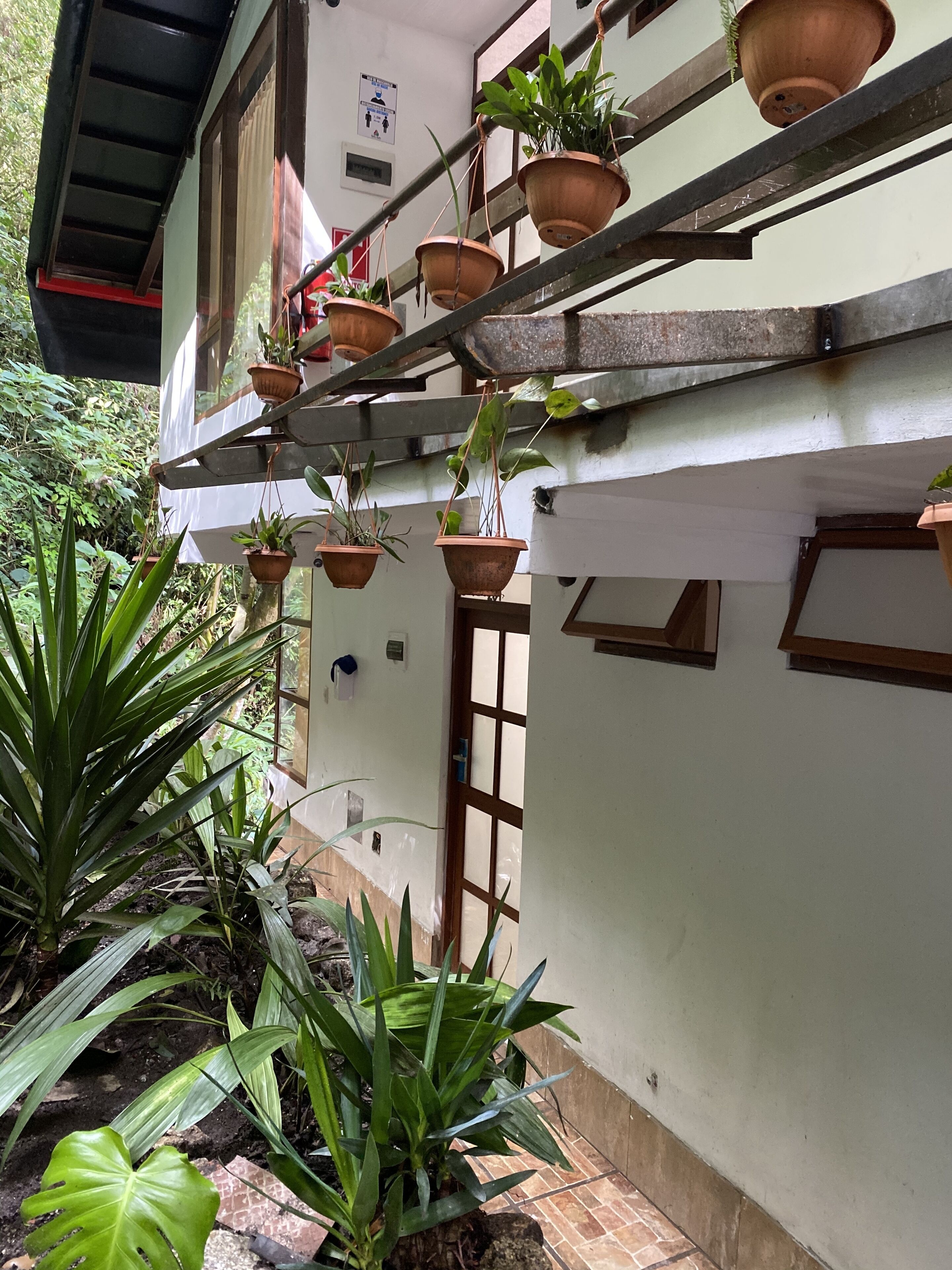 A building with multiple hanging planters on the exterior wall.