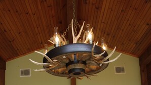 A spacious room with a high ceiling, a wooden dining table, and a traditional Japanese-style interior. - Luxury Mnt. View Cabin with game room, hot tub, fire pit and private ski trails (Au Sable Forks)