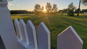 A grassy field with a white fence in the foreground and trees in the background. - A remote getaway ... Enjoy nature, have fun and embrace relaxation! (windsor)