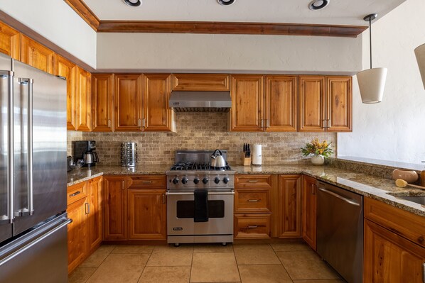 Una cocina con armarios de madera, un refrigerador de acero inoxidable, una estufa y un lavavajillas.