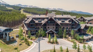 Un grand chalet doté de nombreux balcons et situé à proximité d’un télésiège.
