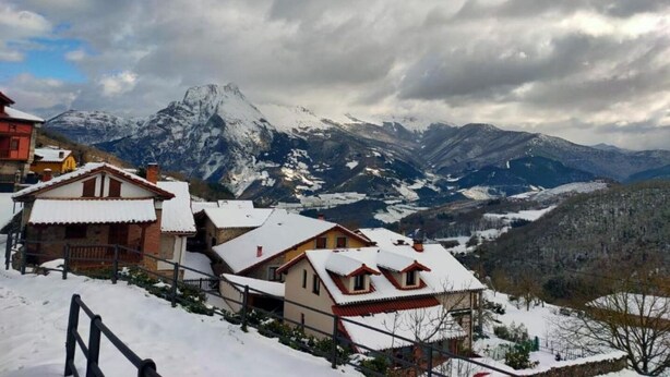 A snow-covered village with traditional houses and a mountain backdrop. - Casa el Enebral (Colio)