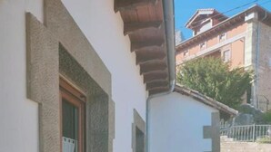 A narrow stone staircase leading to a door, with a window on the left and a white wall. - Casa el Enebral (Colio)
