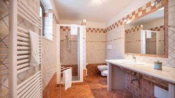 Un bagno con doccia, WC e lavandino.