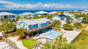 Un quartier résidentiel situé sur la côte, comprenant plusieurs maisons, une piscine et une terrasse en bois.