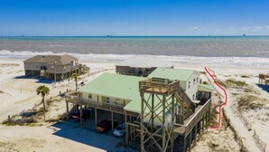 Une propriété située en bord de mer, comprenant plusieurs bâtiments, dont une maison principale dotée d’un toit végétalisé et une autre construction séparée avec une terrasse en bois.