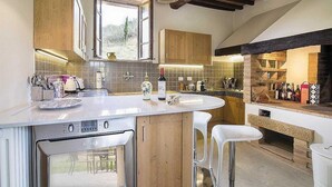 A kitchen with a large island, wooden cabinets, and a stone backsplash.