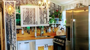 A kitchen with a refrigerator, stove, and dishwasher.