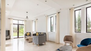 Un salón espacioso con un sofá gris, un sillón azul y una mesita de centro.