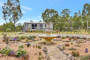 A residential property with a landscaped garden, a fountain, and a statue. - Wallaby Gully Farm Cottage Peace, Quiet, Serenity (Ellalong)