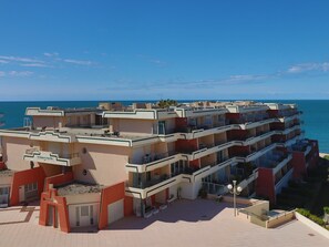 Un hôtel à plusieurs étages doté de balcons donnant sur la mer.