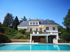 A large house with a swimming pool, a covered patio, and a well-maintained garden. - Gîte-studio "bellevue" (Châteauneuf-de-Galaure)
