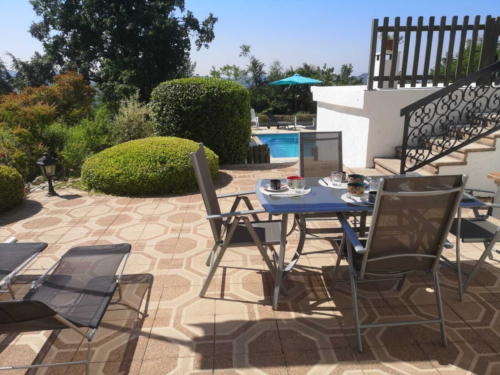 An outdoor patio with a pool, seating area, and staircase.