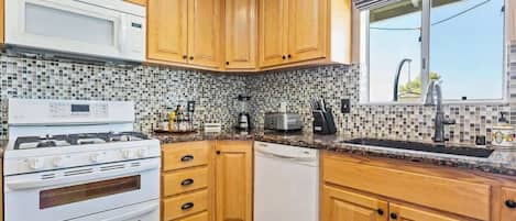 Een koffiezetapparaat/waterkoker, kookgerei, borden en bestek