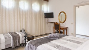 A bedroom with two beds, a desk, a chair, a television, and a mirror. - Small villa near the historic center with free parking (Assisi)