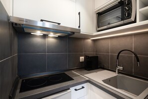 Departamento Deluxe | Cocina privada | Horno, parrilla de estufa, utensilios de cocina y comedor 