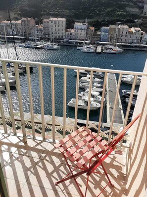 Ein Balkon mit Blick auf eine Marina, Boote und Gebäude.