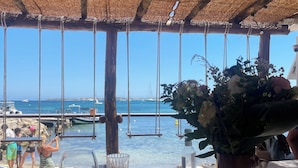 A wooden table with a glass and a bottle, a hanging swing, and a view of the sea. - BALCONY SUR LA MARINE - VUE IMPRENABLE - STUNNING VIEW - BONIFACIO harbor (Bonifacio)