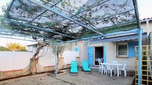 A covered patio area with outdoor seating and a sheltered workspace.