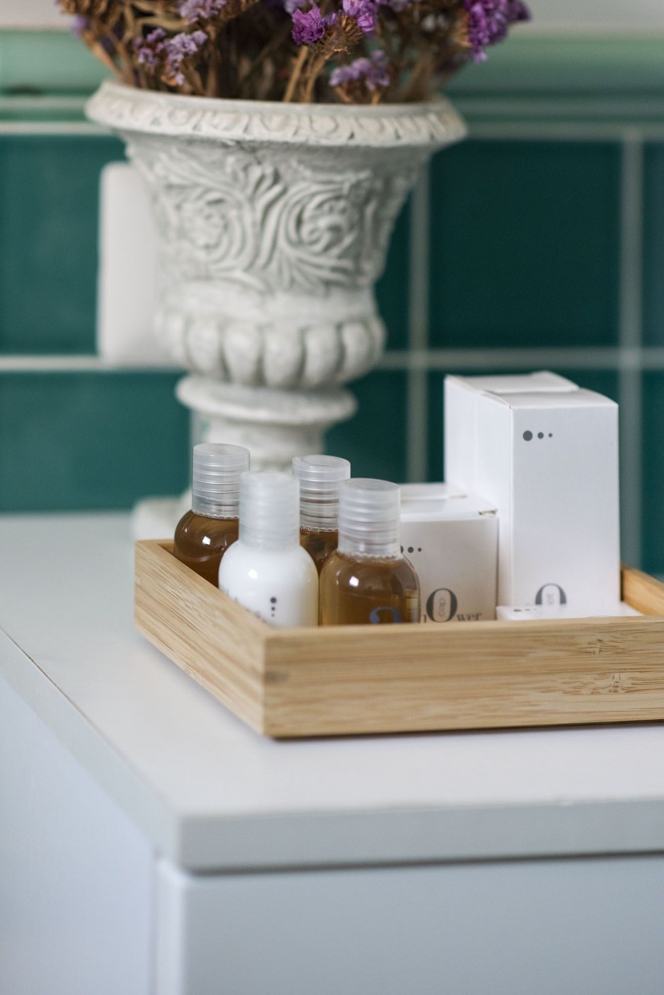 Un plateau en bois avec des bouteilles et des boîtes, posé sur une surface blanche.