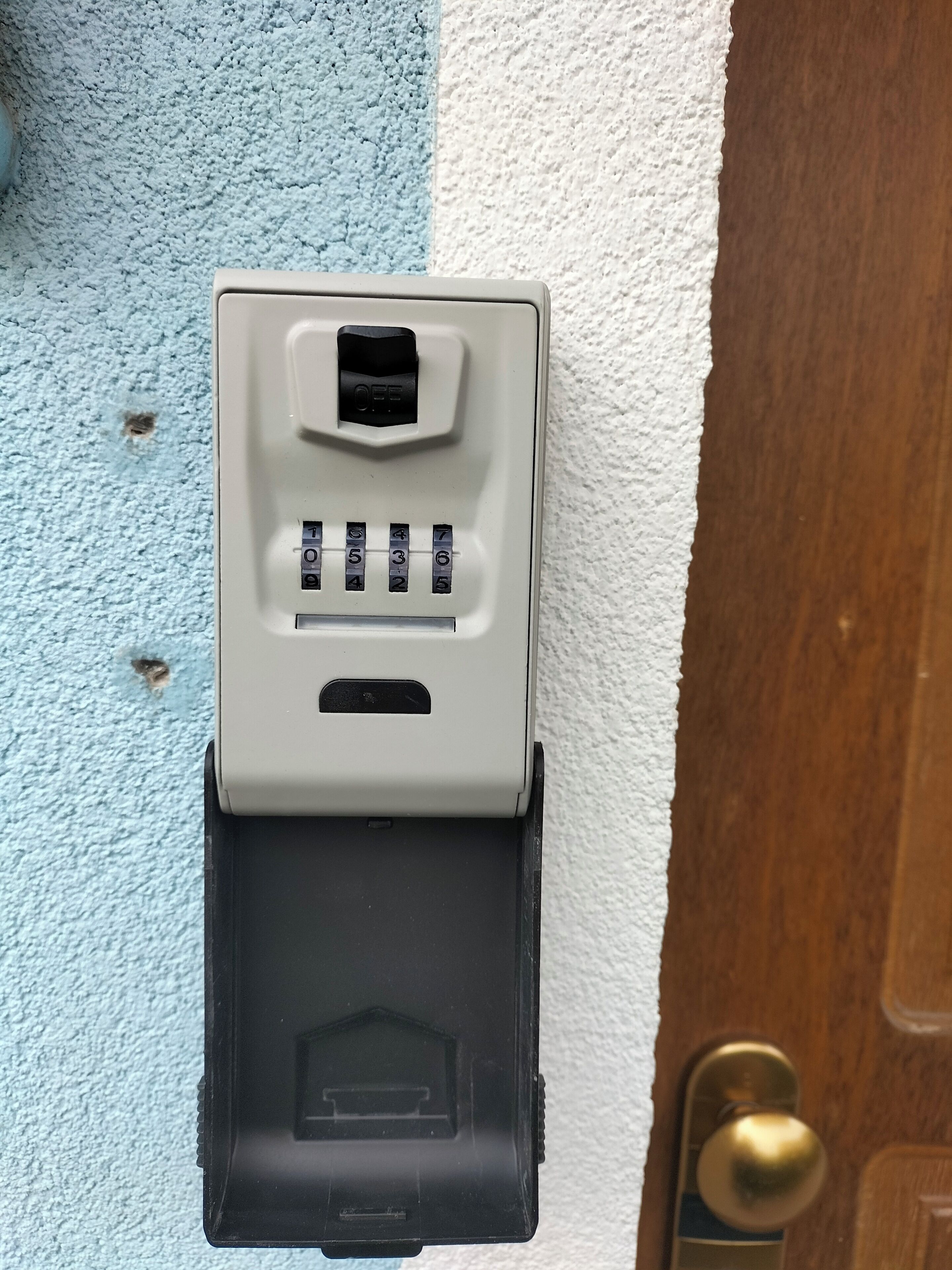 A wall-mounted intercom system with a numeric keypad and a speaker grille.