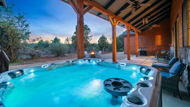 Een hottub onder een houten pergola met uitzicht op het omliggende landschap.