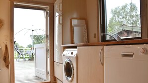 Una cucina compatta con lavatrice, forno integrato e finestra vista esterna.