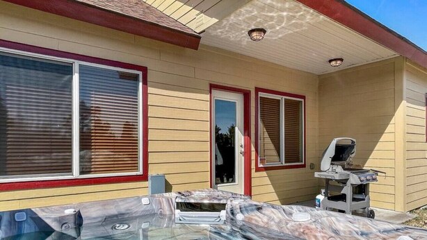 A hot tub area with a grill and a covered table.